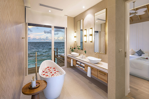 Baño de una Water Villa con bañera frente al mar en Bandos Maldives