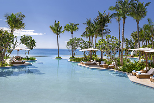Piscina principal y playa de arena blanca en Waldorf Astoria Maldives Ithaafushi